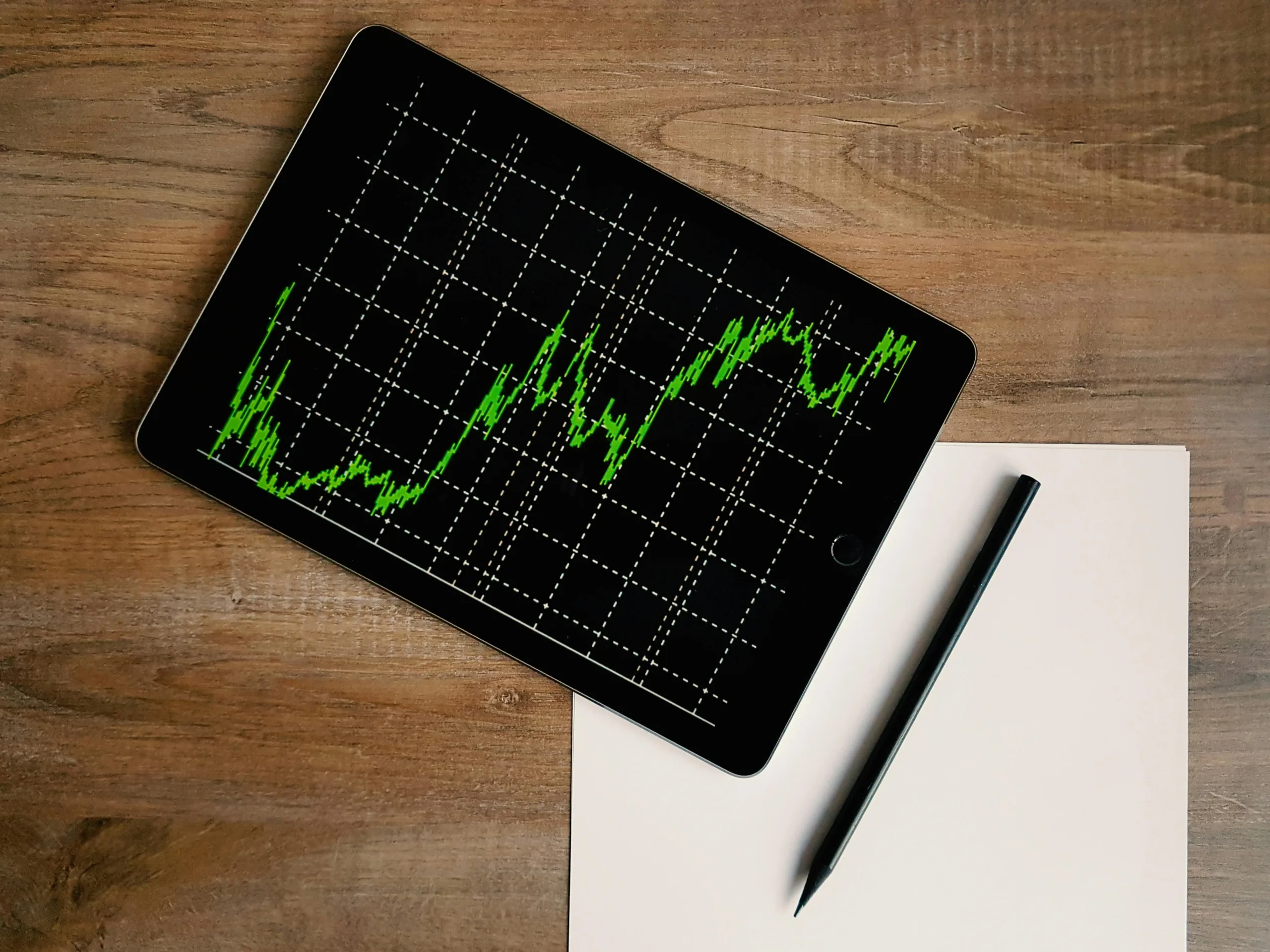 Decorative image to accompany blog on the role of an accountant in business growth. Image of ipad on a desk with a graph in green showing growth.